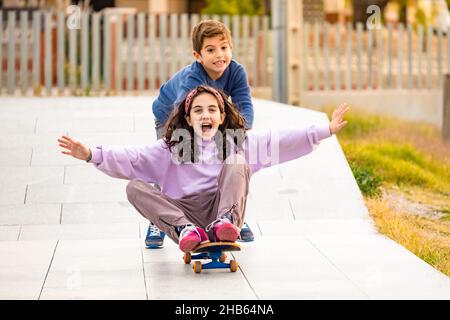 Zwei Freunde spielen mit einem Skateboard Stockfoto