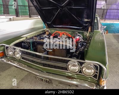 AVELLANEDA, ARGENTINIEN - 06. Dez 2021: Motor eines luxuriösen grünen Ford Fairlane 1970s Limousine. Sportlicher und stilvoller Oldtimer aus Argentinien. Haube offen Stockfoto