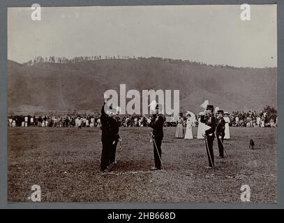 Vereidigung von Offizieren, Vereidigung einer Gruppe von drei Offizieren auf freiem Feld. Ein Offizier nimmt den Eid mit erhobener Hand ab. In der Nähe stehen einige Frauen, aus der Ferne mehr Publikum. Einfahrfoto in einem Album von 87 Fotos über den Bau der Gajo-Straße auf Nord-Sumatra zwischen Bireuen und Takinguen zwischen 1903-1914., anonym, Noord-Sumatra, 1903 - 1913, fotografische Unterstützung, Höhe 138 mm × Breite 200 mm Stockfoto