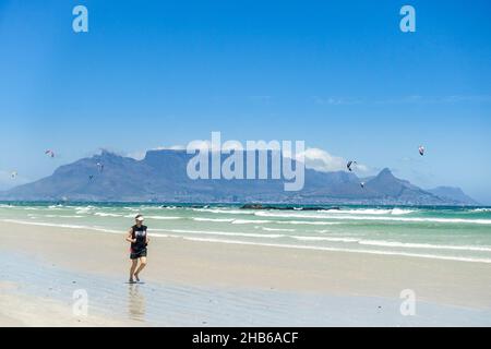 Jogger am Strand von Kapstadt, Südafrika, mit Tafelberg im Hintergrund Stockfoto