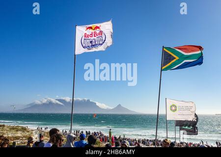 Red Bull-Flagge und andere Flaggen, die während des Red Bull King of the Air 2021 in Blouberg, Kapstadt, Südafrika, in der Luft fliegen Stockfoto