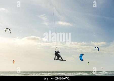 Kitesurfer, der beim Red Bull King of the Air 2021 in Blouberg, Kapstadt, Südafrika, einen Trick in der Luft macht Stockfoto