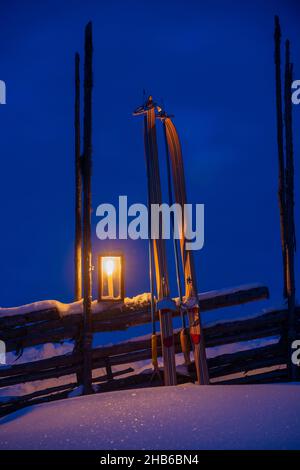 Eine Laterne und Skier und ein schneebedeckter Zaun Stockfoto