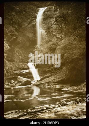 Magische Laterne Rutsche c 1900-1910 Frau stehend in der Ferne unter Wasserfall in felsigen Fluss Schlucht Glenashdale unteren Fällen, Isle of Arran, Schottland Stockfoto