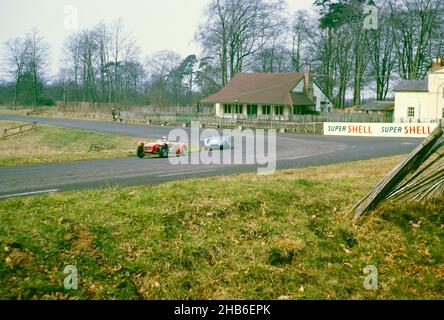 Der britische Sportrennfahrer Bill de Selincourt (1921-2014) fährt Lister-Jaguar mit einem "knobbligen" Auto (blaues Auto), BARC-Event auf der Rennstrecke von Oulton Park, Cheshire, England 17th. März 1962 Stockfoto