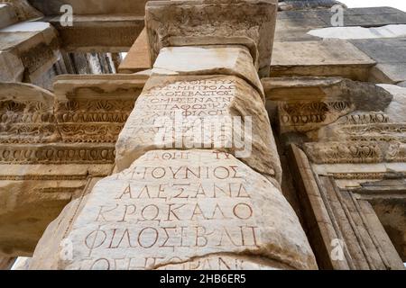 Altgriechische Inschriften an der Wand der Celsus-Bibliothek in der antiken Stadt Ephesus. Stockfoto