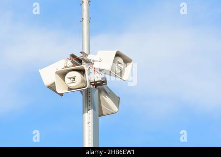 Mehrere Lautsprecher auf Mast, zwei Lautsprecher für Beschallungssysteme auf blauem Himmel Stockfoto