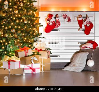 Gemütliche, hell dekorierte Wohnmöbel zu Weihnachten. Ein Weihnachtsbaum mit Weihnachtslichtern und Geschenkschachteln darunter. Weihnachtsstiefel, Weihnachtssocken und Mützen. Stockfoto