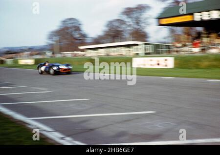 Verschwommenes Foto des britischen Sportrennfahrers Bill de Selincourt (1921-2014), der Lister-Jaguar mit einem „geklopften“ Auto fährt, BARC-Event Goodwood, März 1961 Stockfoto