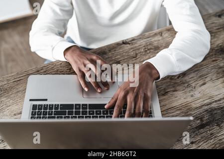 Draufsicht des afrikanischen Mannes, der zu Hause einen Laptop benutzt - Technologiekonzept Stockfoto