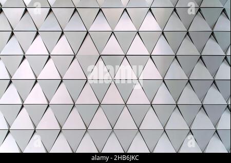 Gebäudestrukturen aus Aluminium-Dreieck-Geometrie an der Fassade moderner Stadtarchitektur Stockfoto