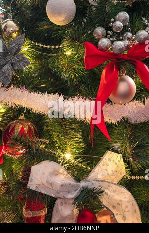 Weihnachtsbaum Nahaufnahme mit Spielzeug und Dekorationen. Weihnachten Hintergrund. Vertikale Ansicht. Stockfoto