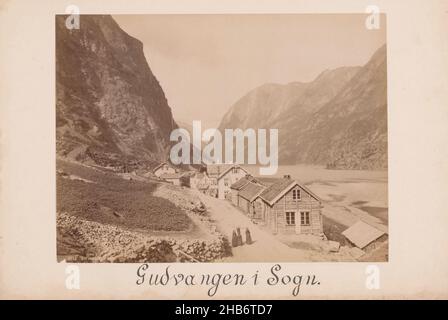 Gudvangen i Sogn, Norwegen, Häuserzeile entlang einer Straße und zwischen steilen Klippen links und einem See rechts. Unterwegs sind drei Frauen in dunkler Kleidung. Gudvangen ist ein Dorf in der Gemeinde Aurland in der Grafschaft Sogn Og Fjordane, Norwegen., Knud Knudsen (erwähnt auf Objekt), Norwegen, c. 1870 - c. 1900, fotografische Unterstützung, Karton, Albumin-Druck, Höhe 162 mm, Breite 215 mmhöhe 203 mm, Breite 309 mm Stockfoto