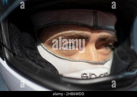 Nahaufnahme eines hübschen jungen Mannes, der einen Formel-1-Rennhelm trägt. Stockfoto