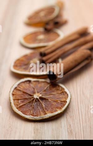 Goiânia, Goias, Brasilien – 15. Dezember 2021: Dehydrierte Orangenscheiben und Zimtstangen für Tee auf einer Holzoberfläche. Stockfoto