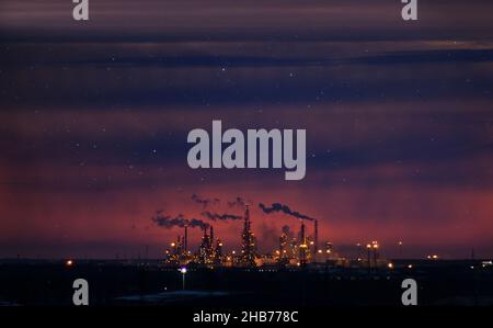 Rauchstapel mit Rauchentwicklung. Anlagenrohre verschmutzen die Atmosphäre. Verschmutzung durch Industriebetriebe. Nachtaufnahmen Stockfoto