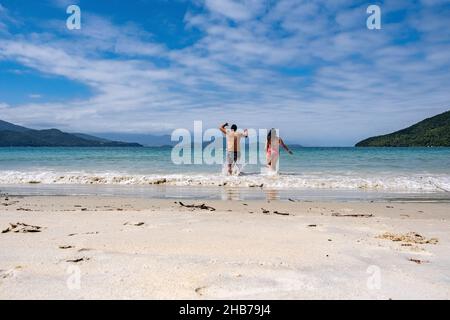 Junges Paar läuft zum Strand glücklich genießen Urlaub in ubatuba brasilien Stockfoto