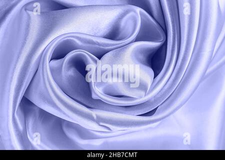 Hellviolett sehr Peri Farbe Seide gewelltes Textilmuster als glatter strukturierter Hintergrund. Blau gefärbter weicher Satin-Stoff-Vorrat. Stockfoto