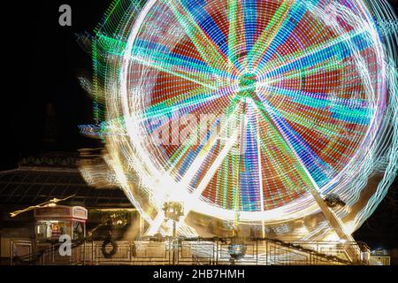 Crescent Gardens, Harrogate, nächtliche Langzeitbelichtung mit gezielter Kamerabewegung, um die Lichtwege eines sich drehenden Riesenrads zu verdecken. Stockfoto