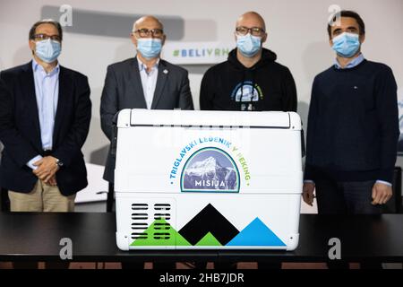 Ljubljana, Slowenien. 17th Dez 2021. (L-R) Zooullis Mina, Geschäftsführer der Brauerei Lasko, Bogdan Gabrovec, Präsident des slowenischen Olympischen Komitees, Ciril Komotar, Automobiljournalist und Vlogger, und Franci Petek, Projektbotschafter und ehemaliger Skispringer, Pose vor einem Kühler mit einem Stück slowenischen Alpengletscher mit dem Spitznamen Toli auf einer Pressekonferenz, bevor die Eisprobe auf eine lange Reise zu den Olympischen Winterspielen in Peking in Ljubljana aufbricht.nach der Pandemie verhinderten Sloweniens Pläne, ein slowenisches Haus in Peking zu bauen Winterolympiade als Teil der p Stockfoto