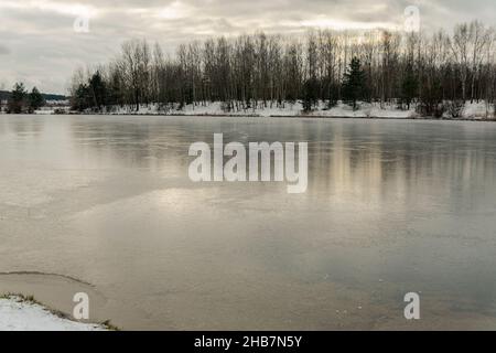 Gefrorener See entlang der Ufer trockene Bäume Wald wird in den Eisbrunchen abgeschnitten werden Stockfoto