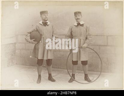 Zwei französische Männer in Kinderkleidung mit Reifen und Ball, Teil des Fotoalbums eines französischen Amateurfotografen mit Aufnahmen einer Familie, Brennerei Delizy &amp; Doistau Fils, der Armee und Sehenswürdigkeiten in Frankreich., anonym, Frankreich, c. 1900 - c. 1910, Papier, Albumin-Druck, Höhe 110 mm × Breite 156 mm Stockfoto