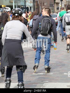 LONDON, VEREINIGTES KÖNIGREICH - 12. Apr 2013: Eine Gruppe von Menschen, die durch die Straßen Londons Rollen Stockfoto