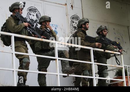 Nablus, Westbank, Palästina. 17th Dez 2021. Israelische Soldaten sichern die Straße während einer Demonstration jüdischer Siedler nach der Tötung eines israelischen Siedlers aus der jüdischen Siedlung Shavei Shomron bei einem Schussangriff auf sein Auto durch palästinensische Jugendliche, die geflohen sind, Und jüdische Siedler griffen Häuser und Fahrzeuge palästinensischer Bürger im Westjordanland in der Nähe der Stadt Nablus an. Kredit: Nasser Ishtayeh/ZUMA Wire/Alamy Live Nachrichten Stockfoto