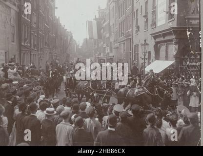 Fahrt von Königin Wilhelmina und Prinz Hendrik zum Wester-Suikerraffinaderij in Amsterdam, die Kutsche mit Königin Wilhelmina und Prinz Hendrik wendet sich von der Binnen Brouwersstraat in die Haarlemmerstraat. Zuschauer stehen entlang der Strecke. Rechts an der Ecke ein Schuhgeschäft von L. Paanakker., anonym, Niederlande, 26-Sep-1904, Papier, Albumin-Print, Höhe 110 mm × Breite 150 mm Stockfoto