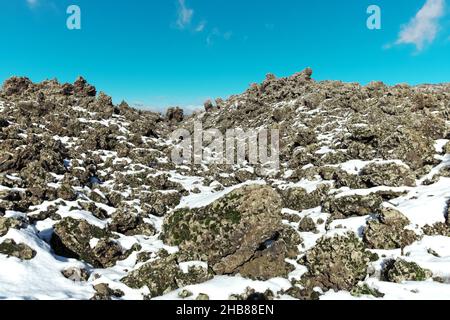 Alte Lavagestein Schnee bedeckt im Winter Ätna Park, Sizilien Stockfoto