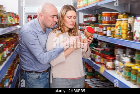 Lächelndes Paar, das konservierte Waren hält Stockfoto