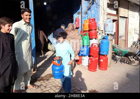 Hyderabad, Pakistan. 17th Dez 2021. Die Bürger füllen ihre Gasflasche in einem Geschäft mit Flüssiggas auf, da die Bewohner während der Wintersaison an der Burns Road in Karachi am Freitag, dem 17. Dezember 2021, mit einem Mangel an Sui-Gas konfrontiert sind. Kredit: Asianet-Pakistan/Alamy Live Nachrichten Stockfoto