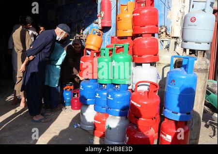 Hyderabad, Pakistan. 17th Dez 2021. Die Bürger füllen ihre Gasflasche in einem Geschäft mit Flüssiggas auf, da die Bewohner während der Wintersaison an der Burns Road in Karachi am Freitag, dem 17. Dezember 2021, mit einem Mangel an Sui-Gas konfrontiert sind. Kredit: Asianet-Pakistan/Alamy Live Nachrichten Stockfoto