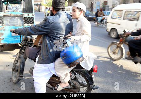 Hyderabad, Pakistan. 17th Dez 2021. Die Bürger füllen ihre Gasflasche in einem Geschäft mit Flüssiggas auf, da die Bewohner während der Wintersaison an der Burns Road in Karachi am Freitag, dem 17. Dezember 2021, mit einem Mangel an Sui-Gas konfrontiert sind. Kredit: Asianet-Pakistan/Alamy Live Nachrichten Stockfoto