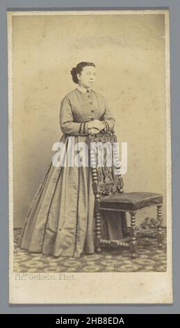 Porträt einer unbekannten Frau in der Nähe eines Stuhls, Théodore Gedoelst (auf Objekt erwähnt), Louvain, 1866 - 1883, Karton, Papier, Albumin-Print, Höhe 106 mm × Breite 60 mm Stockfoto