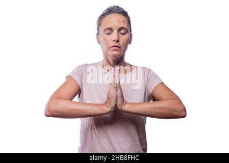 Eine Erwachsene Frau, die in Gebetshaltung meditiert Stockfoto