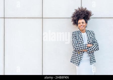 Schwarze Frau in Kleid, Karlowjacke und gekreuzten Armen. Stockfoto