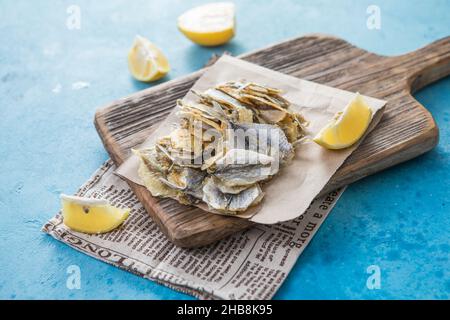 Getrocknete gelbe Zwergwale auf blauem Hintergrund. Biersnack, getrocknete Meeresfrüchte. Industrieller Fang, Schablone Stockfoto