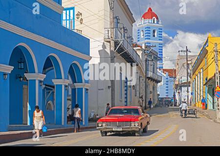 Rot-amerikanischer Oldtimer und Glockenturm des Parroquial Mayor, Kubas älteste Kirche in der Stadt Sancti Spíritus auf der Insel Kuba, Karibik Stockfoto