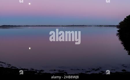 Angus, Großbritannien. 17th Dez 2021. UK Weather, Montrose Basin, Angus, Scotland, UK 17th of Dec 2021: Im Bild - das Montrose Basin in Angus, während die Sonnenuntergänge und der Mond seinen Platz einnehmen, was zu einem dramatischen Himmel voller Farben führt, da die Temperatur heute Abend in Montrose auf -1 sinkt. Kredit: Barry Nixon/Alamy Live Nachrichten/Alamy Live Nachrichten Stockfoto