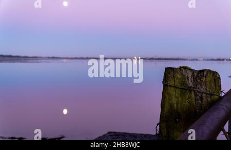 Angus, Großbritannien. 17th Dez 2021. UK Weather, Montrose Basin, Angus, Scotland, UK 17th of Dec 2021: Im Bild - das Montrose Basin in Angus, während die Sonnenuntergänge und der Mond seinen Platz einnehmen, was zu einem dramatischen Himmel voller Farben führt, da die Temperatur heute Abend in Montrose auf -1 sinkt. Kredit: Barry Nixon/Alamy Live Nachrichten/Alamy Live Nachrichten Stockfoto