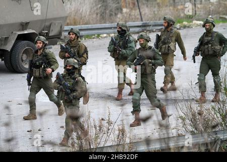 Nablus, Palästina. 17th Dez 2021. Israelische Soldaten sichern die Straße während einer Demonstration. Jüdische Siedler protestierten nach der Tötung eines israelischen Siedlers aus der jüdischen Siedlung Shavei Shomron bei einem Schussangriff auf sein Auto durch die palästinensischen Jugendlichen, die geflohen waren, Und die jüdischen Siedler griffen Häuser und Fahrzeuge palästinensischer Bürger im Westjordanland in der Nähe der Stadt Nablus an. Kredit: SOPA Images Limited/Alamy Live Nachrichten Stockfoto