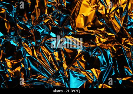Folienhintergrund. Zerknitterte Folie. Abstrakter Hintergrund. Hintergrundbild. Gelb und blau Stockfoto