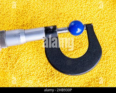 Mikrometer mit bunten Kunststoffperlen. Mikroplastik. Industriekunststoff. Stockfoto