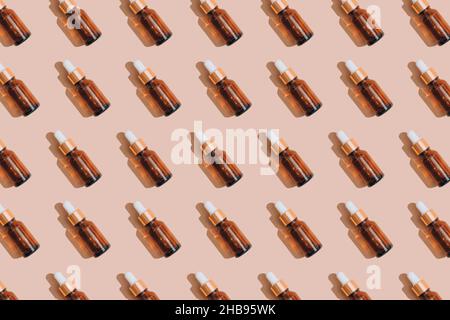 Muster aus Glas Tropfflaschen mit ätherischem Öl, Hyaluronsäure oder Serum auf pastellbeigem Hintergrund. Mockup-Bild. Moderne Bio-Kosmetik Stockfoto