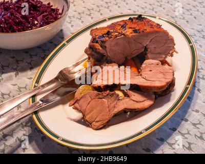 Jungschwein-Schweinchen, gebratenes Haunch oder Bein mit rotem Kohl und Honigkruste Stockfoto