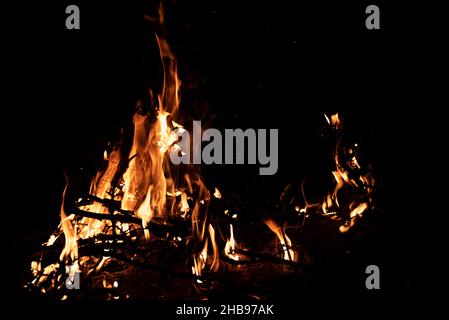 Nachts brennt ein Feuer. Feine Äste im Feuer. Das Feuer anzünden. Stockfoto