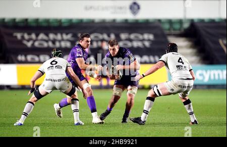 Die Drachen Ben Carter kämpfen gegen den Lyoner Felix Lambey (links) und Killian Geraci (rechts) während des EPCR Challenge Cup Gruppe-B-Spiels bei der Rodney Parade in Newport. Bilddatum: Samstag, 17. Dezember 2021. Stockfoto