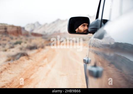 Mann, der in Utah fährt, Gesichtsansicht vom Seitenspiegel Stockfoto