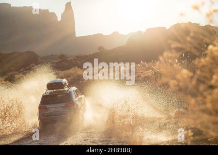 Jeep fährt durch Pfütze, spritzt Wasser in Utah Stockfoto